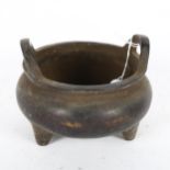 A Chinese bronze tripod censer of circular form, with 2 handles and character mark to the base,
