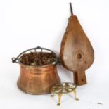 An Antique copper and iron hanging cauldron, pair of bellows, and a brass trivet (3)