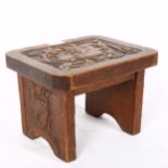 An Arts and Crafts carved oak griffin footstool, with carved side panels, W27cm, H20cm, D22cm No