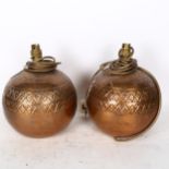 A pair of Middle Eastern embossed copper globular table lamps, height 28cm