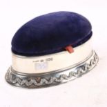 An Edward VII silver pin cushion/jewel box, blue velvet and red interior, on an embossed silver