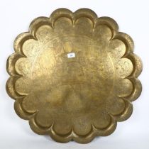 A large Indian engraved brass tray, with lobed border and figural decoration, diameter 73cm