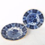 A graduated pair of 18th century Dutch Delft peacock pattern chargers, both marked, diameters 31cm