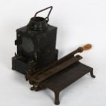 A small black painted metal oil lantern, and a paper guillotine (2)