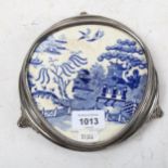 A silver plated teapot stand, on cast scrolled feet, with inset Willow pattern plaque