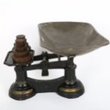 A set of black cast-iron balance scales, with graduated set of weights