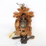 A German Black Forest cuckoo clock, case height 40cm, with weights and pendulum
