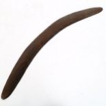 An Australian Aboriginal carved wood boomerang, length 60cm Boomerang has been split and re-glued