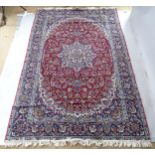 A modern machine-made red and blue ground Kashmiri carpet, 290cm x 186cm