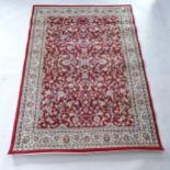 A modern red ground Turkish rug with floral design, 195cm x 138cm