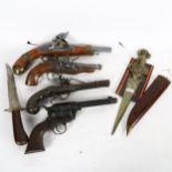 A group of reproduction replica pistols, a knife in wooden scabbard etc