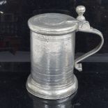 A 19thc pewter tankard, with armorial to the lid.