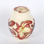 A Moorcroft cream ground jar and cover, with tube-lined orchid design, height 11cm