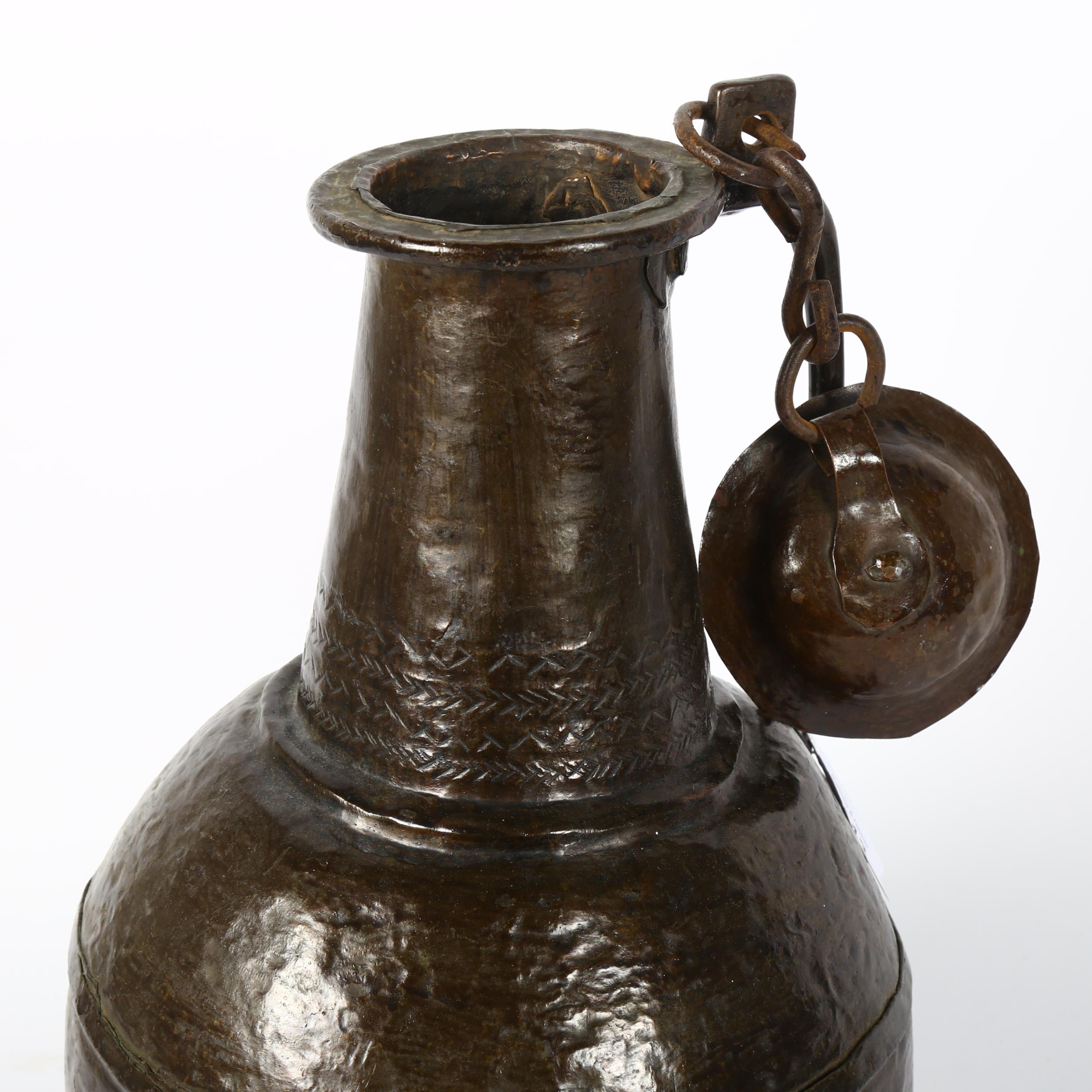 A Middle Eastern handmade copper wine flagon and cover, engraved geometric decoration to the lid, - Image 2 of 2