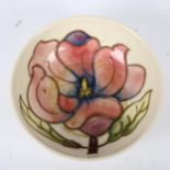 A Moorcroft cream ground dish, with tube-lined flower design, 11.5cm