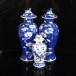 A pair of Chinese blue and white prunus decorated baluster vase and covers, with 4 character mark to