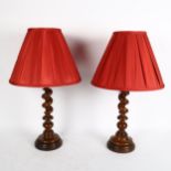 A pair of barley twist turned wood candlestick lamps with red shades, height 49cm