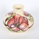 A Moorcroft cream ground vase and cover, with floral design, height 11cm