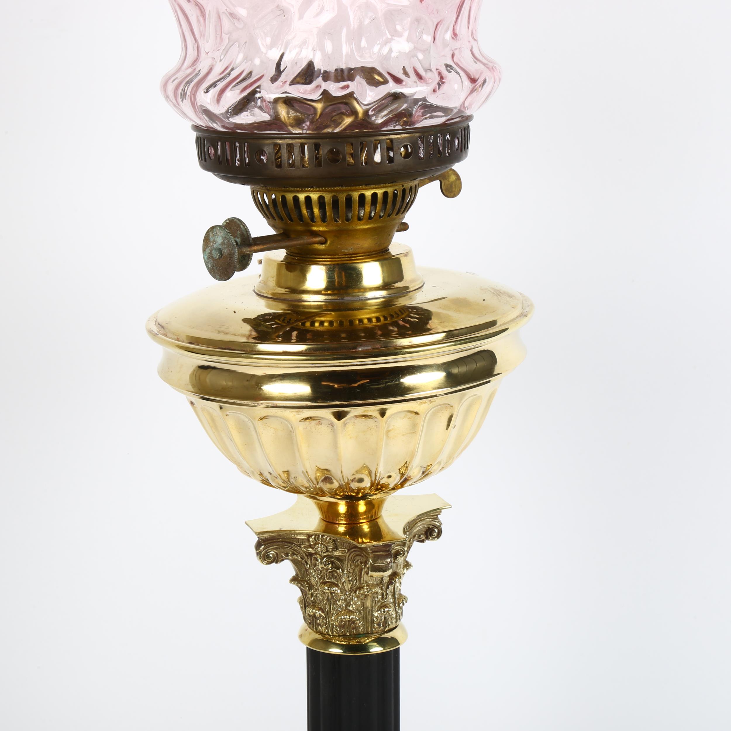 An early 20th century brass duplex Corinthian column oil lamp, with cranberry glass shade and - Image 2 of 2