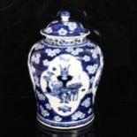 A large Chinese blue and white ginger jar and cover, with genre panels on prunus decorated ground,