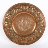 A Gothic Art Nouveau copper church alms plate, relief embossed heart and grapevine surround,
