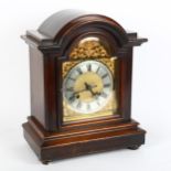 A mahogany dome-top 8-day mantel clock, brass dial with silvered chapter ring, and movement striking