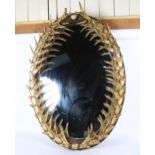A large simulated staghorn antler oval wall mirror, 106cm x 72cm
