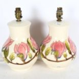 A pair of Moorcroft cream ground table lamps, with tube-lined floral decoration, height overall 30cm