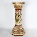 An embossed pottery floor standing jardiniere stand, with cherub and garland decoration, height 62cm