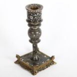 A silver and brass inlaid candlestick on a pierced brass and enamel inlaid plinth base, height 19cm