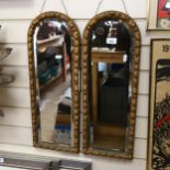 A pair of bevel-edge arch-top wall mirrors, in embossed gilded frames, height 63cm