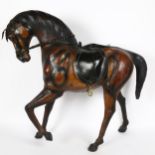 A large Antique leather-covered horse figure, height 66cm, length 66cm A few leather splits on legs,