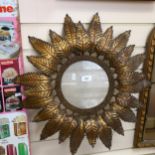 An ornate circular picture frame, with gilded pressed metal foliate design surround, 53cm across