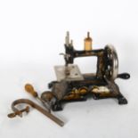 A Vintage cast-iron children's sewing machine, with wooden reel and Singer sticker, made in Germany,