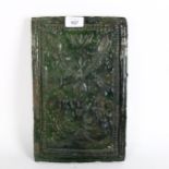 A Continental green glazed earthenware plaque, with stylised embossed decoration, height 31cm