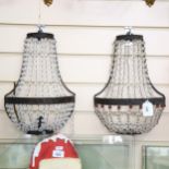 A pair of embossed metal wall light fittings, with chains of bead drops, height 34cm