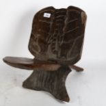 A carved African wood 2-section chair, with the frontal view of an elephant carved into the back