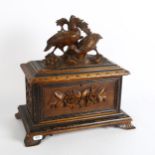 A 19th century carved and stained wood Black Forest tea caddy, with fitted interior, the rising