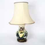 A Moorcroft tube-lined table lamp with spring flower design, and shade, height 58cm overall