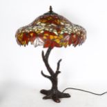 A Tiffany style table lamp and shade, with tree style support and leaf decorated shade, 61cm