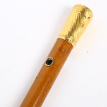 A 19th century Malacca walking cane, with unmarked yellow metal knop, engraved with rampant lion