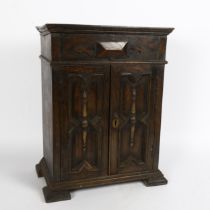 A 17th century style oak table-top armoire apprentice piece, geometric moulded doors, with