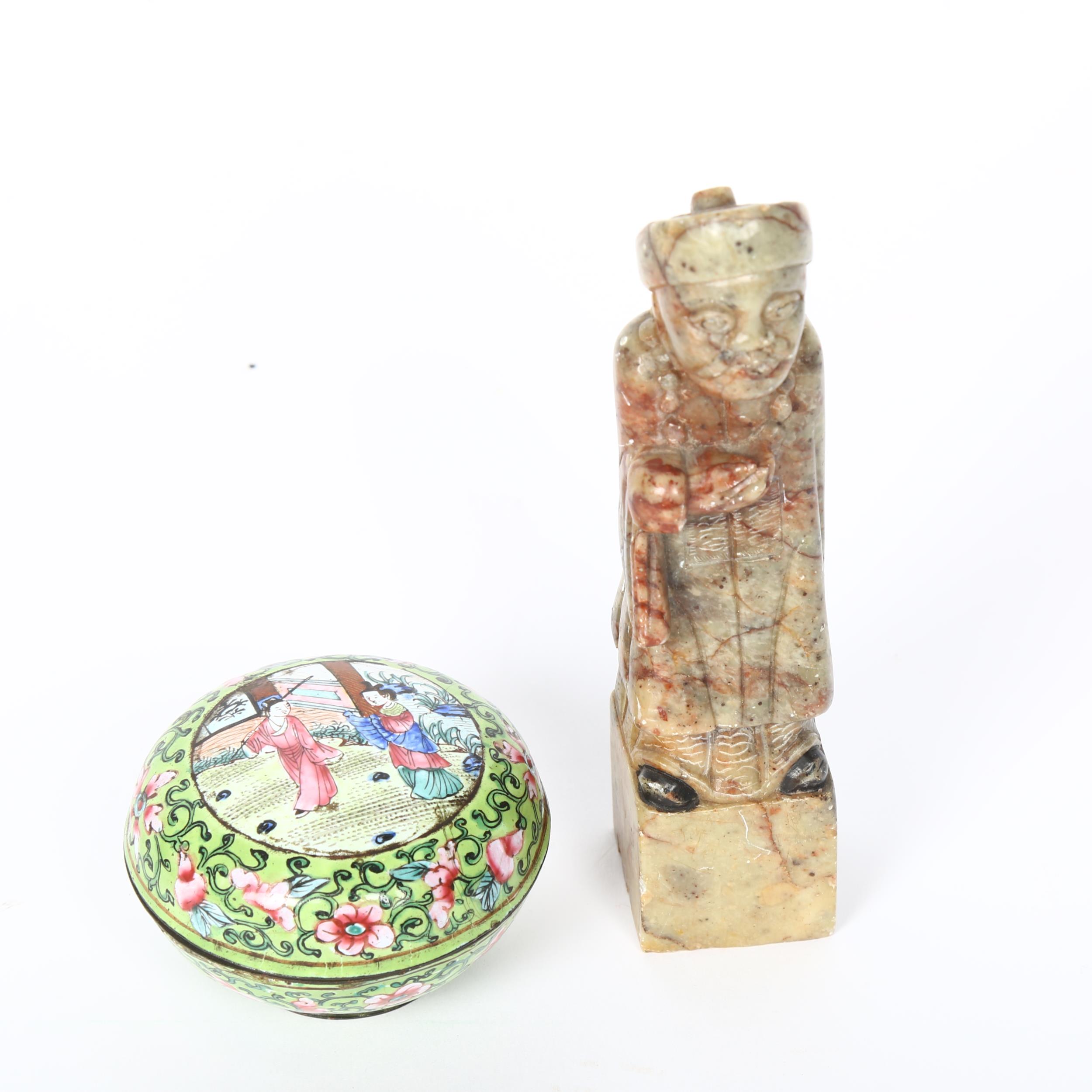 A Chinese soapstone standing figure, height 13cm, and a small enamelled metal pot, diameter 6cm (2)