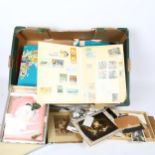 A quantity of postage stamp stock books, cigarette cards, family photographs etc (2 boxes)