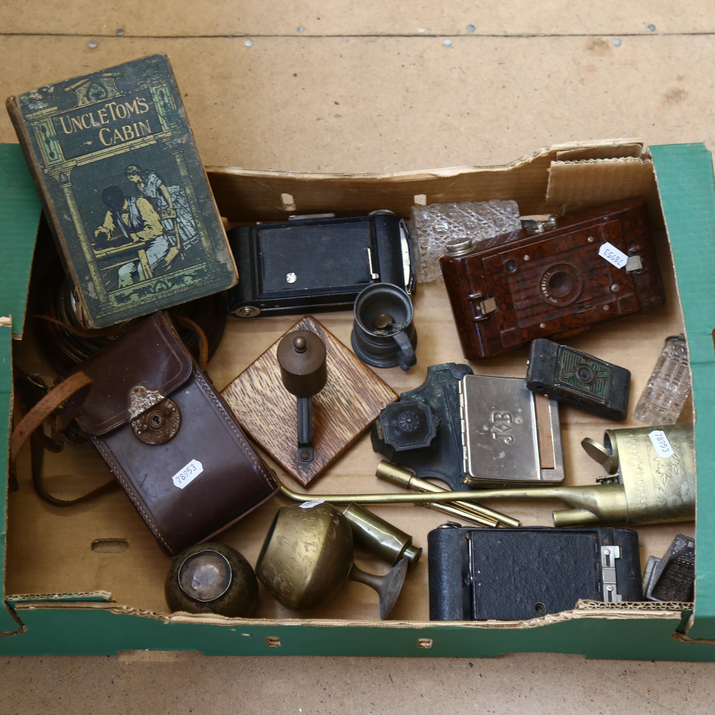 An Oriental brass opium pipe, oak-framed barometer, folding cameras, desk stand, and Uncle Tom's