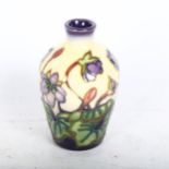 A Moorcroft vase with tube-lined mauve flower decoration, height 9cm, boxed
