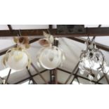 A pair of globular ceiling lights with floral metal decoration, and a small brass chandelier with