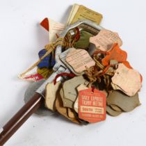 A mid-20th century aluminium shooting stick, with various paddock passes and badges, including