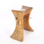 An African wood neck rest with engraved sides, height 19cm