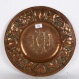 A Gothic Art Nouveau copper church alms plate, relief embossed heart and grapevine surround,